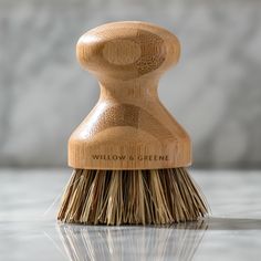 a close up of a wooden brush on a white surface with the words willow & greene written on it