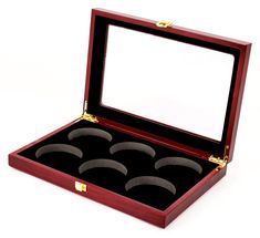 an open wooden box with four rings in it