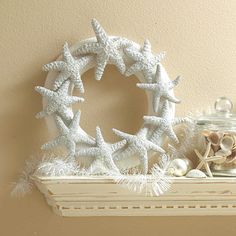 a white shelf topped with starfish and shells