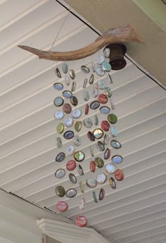 a wind chime hanging from the side of a house with shells and other things on it