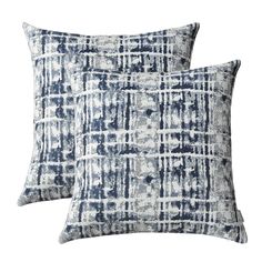 two blue and white pillows sitting next to each other