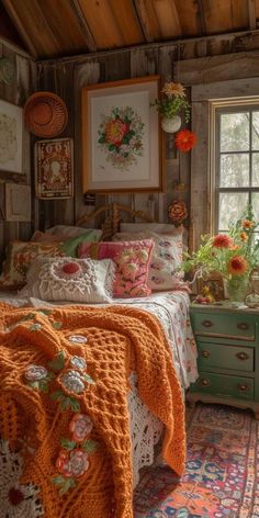 a bedroom with a bed, dresser and window covered in orange crocheted blankets