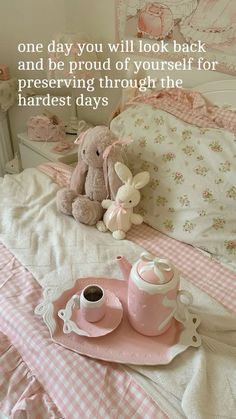 a teddy bear sitting on top of a bed next to a cup and saucer