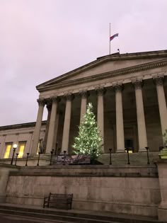 a large building with columns and a christmas tree