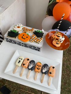 an assortment of halloween treats on sticks and plates