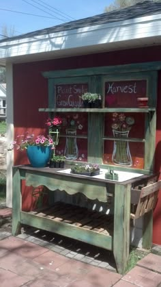 a potted plant sitting on top of a wooden bench next to a red building