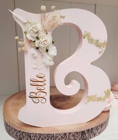 there is a pink and gold wedding cake topper with flowers on the number eight