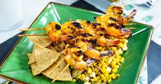 a green plate topped with shrimp and corn