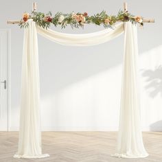 an arch decorated with flowers and greenery for a wedding ceremony or special occasion, in front of a white wall