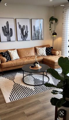 a living room with two couches, a coffee table and three pictures on the wall