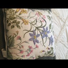 a white pillow with purple and yellow flowers on it