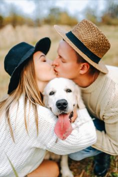 a man and woman kissing with a dog