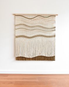 a white wall hanging on the side of a wooden floor