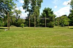 an empty soccer field with goal posts and trees in the backgroung area