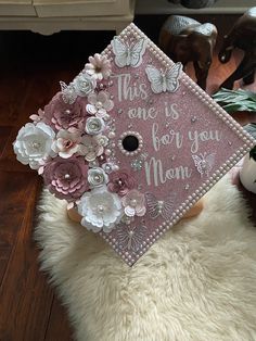 a pink graduation cap with flowers on it that says, this one is for you mom