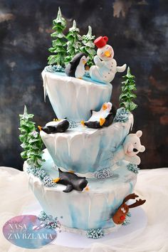 there is a three tiered cake with penguins on it