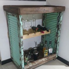 an old cabinet with wine glasses and bottles on it