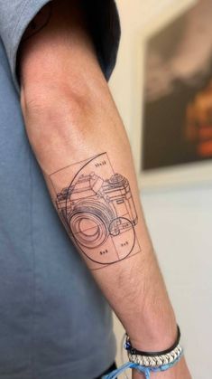 a man with a camera tattoo on his arm