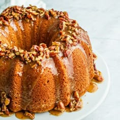 a bundt cake covered in pecans and drizzled with caramel