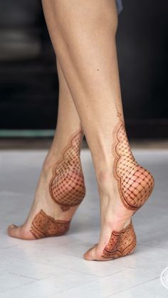 the legs and feet of a woman with henna tattoos