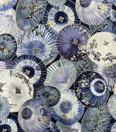 many blue and white parasols are arranged in the shape of an abstract pattern