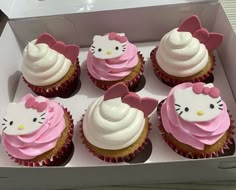 hello kitty cupcakes with pink frosting and white icing in a box