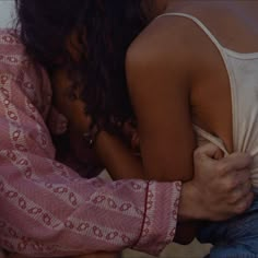 two people hugging each other on the beach