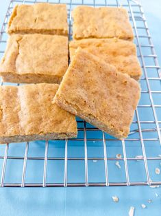 four squares of food sitting on top of a cooling rack next to a blue table