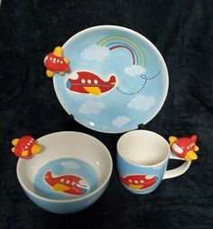 three children's dishes and cups with airplane designs