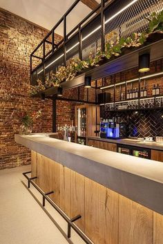 a bar with brick walls and plants on the top shelf, along with metal railings