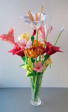 a vase filled with paper flowers on top of a table