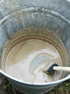 a bucket filled with mud and a plunger