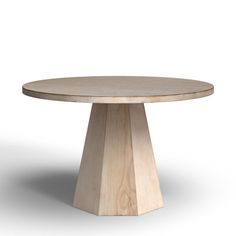 a round wooden table sitting on top of a white floor