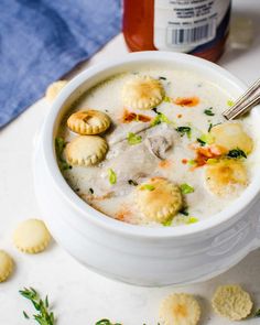 a white bowl filled with soup next to crackers