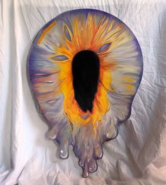 an eyeball is shown on a white sheet with water droplets around it and the iris appears to be orange