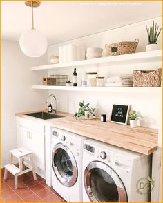 a washer and dryer sitting in a room next to a counter with plants on it