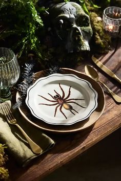 there is a plate with a spider on it next to other plates and silverware