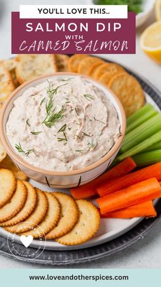 a plate with crackers, carrots and dip on it