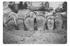 four people are sitting in the sand with their feet sticking out from underneath each other