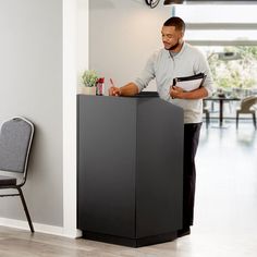 a man standing behind a black podium in a room