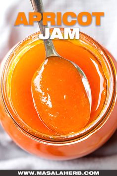 an orange jam in a glass jar with a spoon on it and the words apricot jam