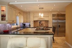 a kitchen with white cabinets and granite counter tops, along with an island in the middle