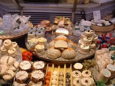 an assortment of cheeses and other foods on display