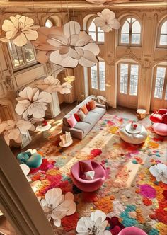 a large living room filled with furniture and flowers on the wall above it's windows