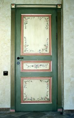 a green door with two pictures on the front and side panels, in an old building