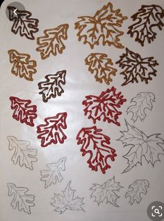 a bunch of cut out leaves sitting on top of a white table covered in frosting