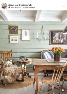 a dining room with chairs, table and pictures on the wall above it that are framed by wood planks