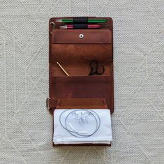 a wallet with scissors, pencils and other items in it