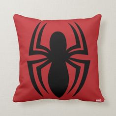 a red pillow with a black spiderman logo on it's front and back