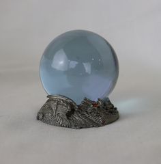 a glass ball sitting on top of a table next to an alligator's head